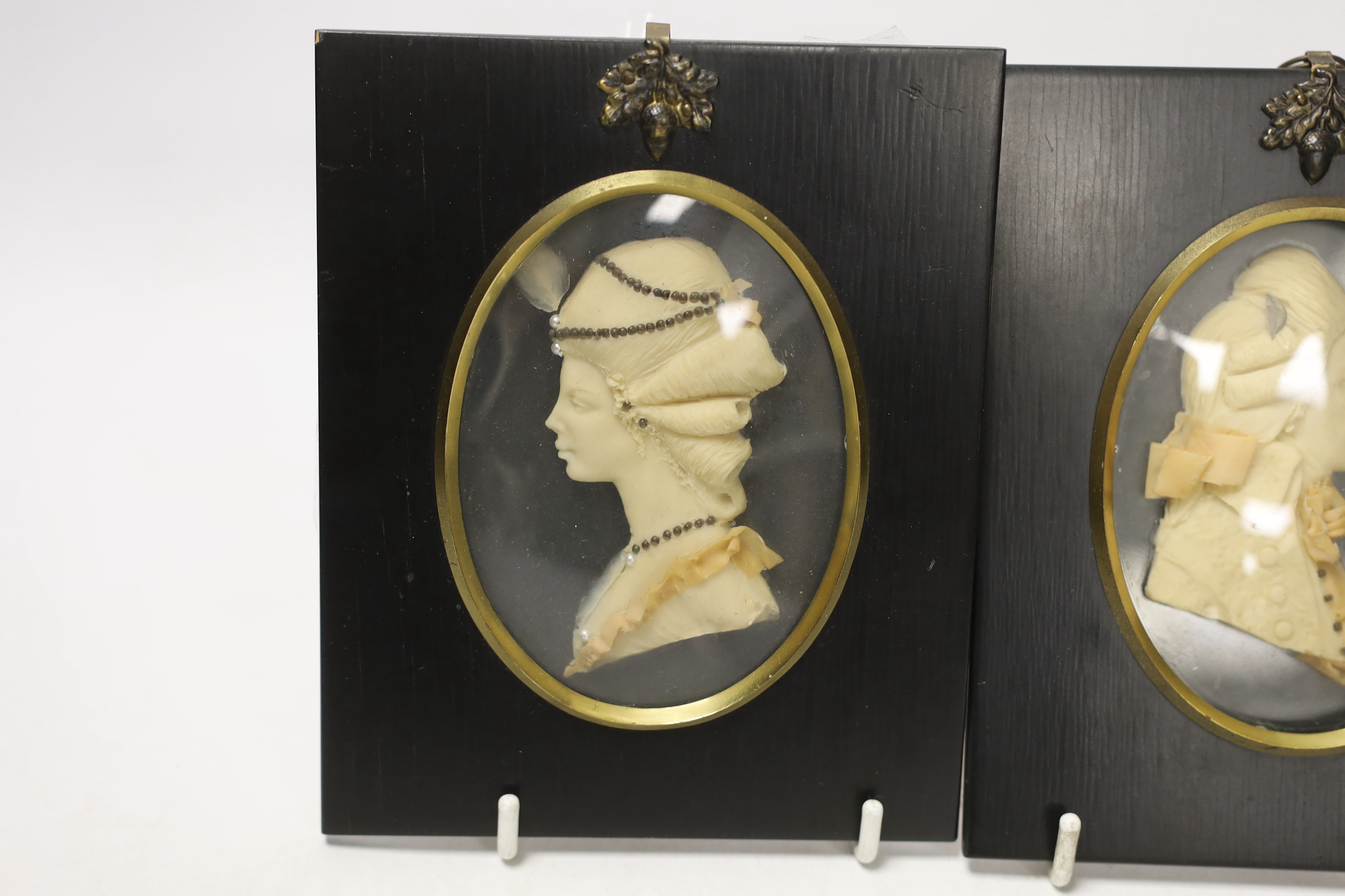 Attributed to Leslie Ray, pair of 20th century wax relief portraits of a lady and gentleman wearing 18th century dress, 15cm high including the frame